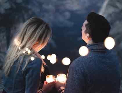 Man and woman surrounded by fairy lights